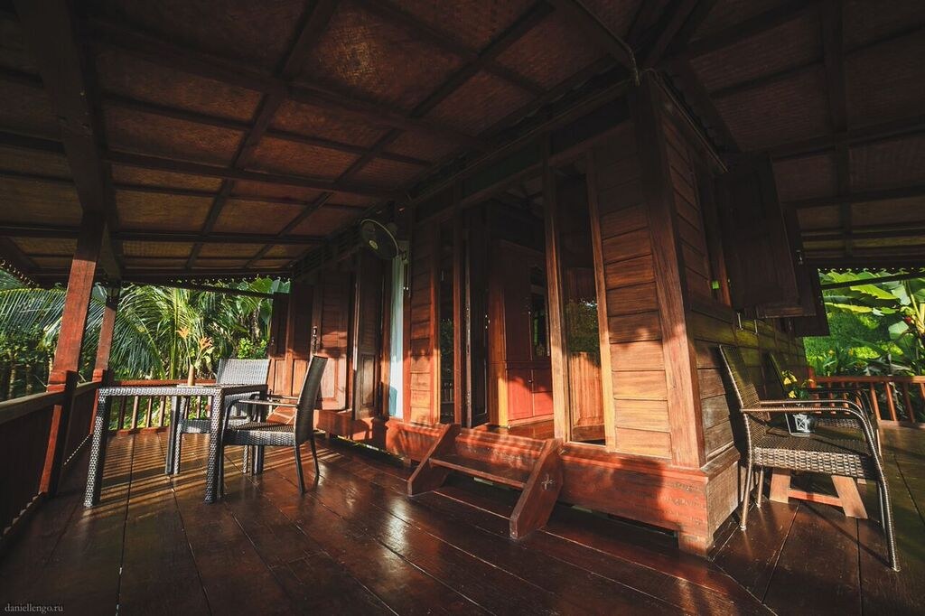 Warm light across a traditional Malay timber veranda